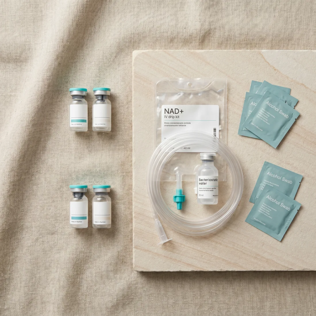 The full Summer Protocol kit laid out, Retatrutide and MOTS-c vials, NAD+ IV drip kit, bacteriostatic water and alcohol swabs